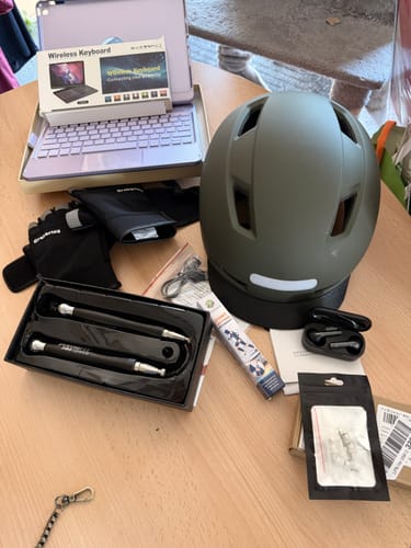 Un cliente mostra i vari articoli del Mystery Pack, tra cui un casco, una tastiera e degli auricolari.